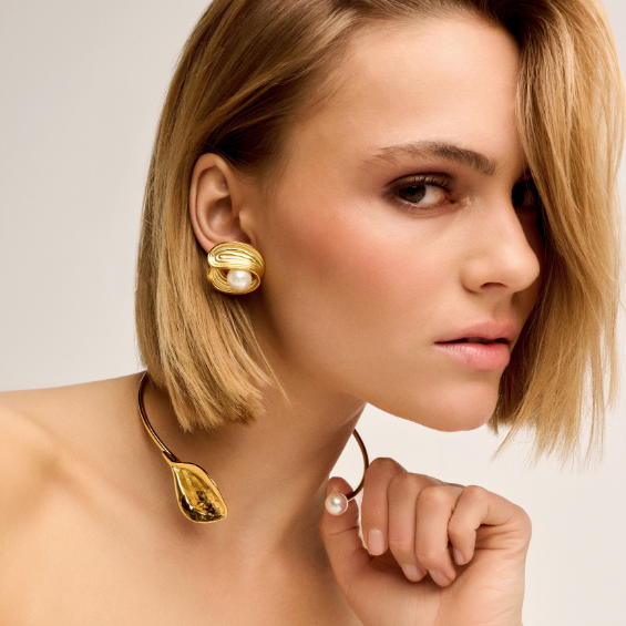 Model draagt een gouden oorbel en nek accessoire uit de TWICE AS NICE collectie