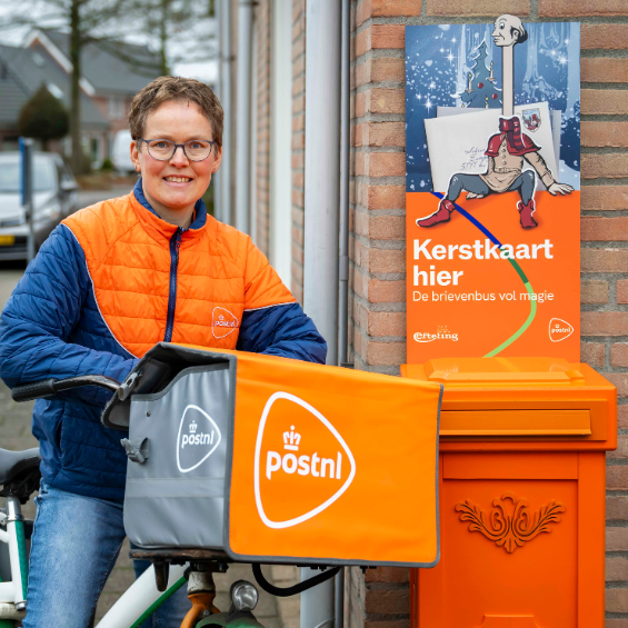 Vrouw bij PostNL kerstbrievenbus