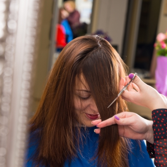 Vrouw bij de kapper die een pony laat knippen
