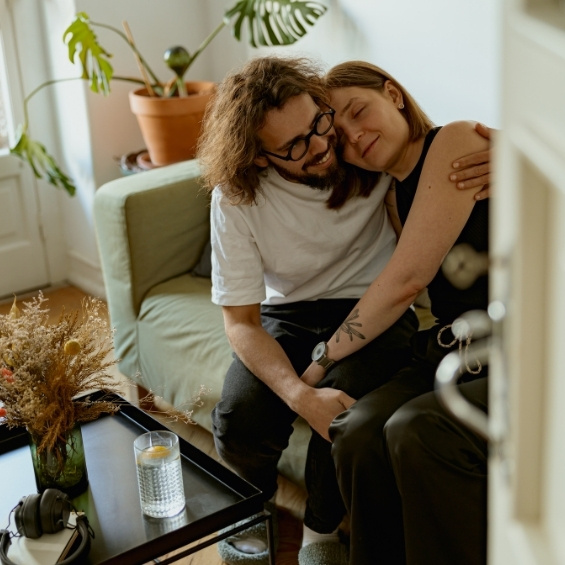 Man en vrouw knuffelend in huis op de bank